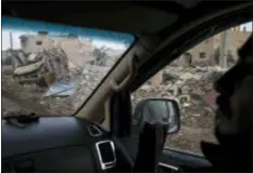  ?? FELIPE DANA — THE ASSOCIATED PRESS ?? A U.S.-backed Syrian Democratic Forces (SDF) fighter rides past destroyed homes and vehicles in a village recently retaken from Islamic State militants in Susah, Syria, Saturday.