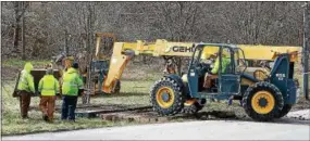  ?? CHRIS BARBER — DIGITAL FIRST MEDIA ?? Heavy equipment operators construct a stepping-stone bridge of sorts across the muddy ditch to access the train.