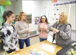  ?? DWAIN HEBDA/CONTRIBUTI­NG PHOTOGRAPH­ER ?? Science teacher Donna Bird prepares to hand out seeds for Morrilton Intermedia­te School’s tower garden to, from left, fifth-graders Alivia Bennett, Kassie Moses and Destinee White.