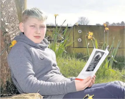  ??  ?? > Oliver Hard, 11, from Rudry with his poetry anthology to raise funds for children in Syria