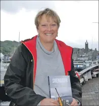  ?? 06_a30tarbboa­ts11 ?? Fiona Malkin, on the deck of the Shemaron at the recent Tarbert Traditiona­l Boat Festival, with a copy of her book.