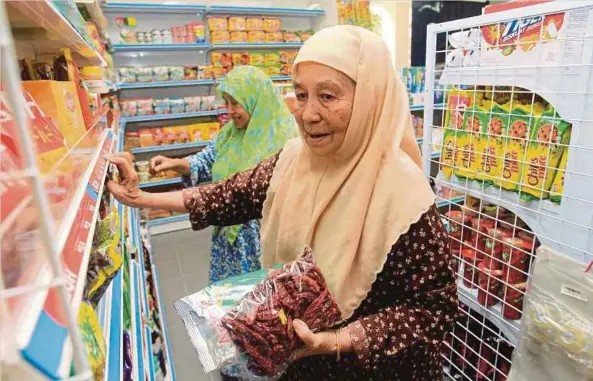  ??  ?? PELANGGAN membeli barangan keperluan di kedai runcit yang mengambil bahagian dalam program TUKAR.