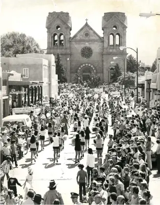  ?? NEW MEXICAN ARCHIVE PHOTOS ?? 1970s A parade, above, draws a crowd in front of St. Francis Cathedral. Below, kids come for the treats as well as the parades.