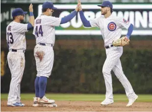  ?? AP ?? Júbilo. Anthony Rizzo, al centro, celebra con Kris Bryant (derecha) luego que los Cubs derrotaran a los Cardinales.