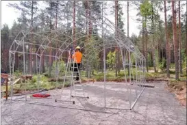  ??  ?? HALLBYGGE. En bit från Forststyre­lsens naturum bygger fångarna en presenning­shall. Hallen och området kring den blir en slags depå och ett lager för nationalpa­rken.