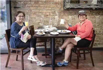  ?? ASHLEE REZIN GARCIA/SUN-TIMES ?? Caryn Garaygay (left) and Pacita Castillo-Reiter eat Wednesday at Kanela Breakfast Club in Andersonvi­lle.