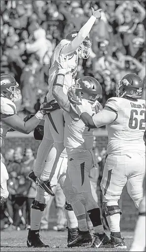  ?? NWA Democrat-Gazette/BEN GOFF ?? Arkansas kicker Connor Limpert (top) celebrates with teammates Austin Cantrell (center), Colton Jackson (left) and Johnny Gibson after kicking a game-winning 34-yard field goal with four seconds remaining against Ole Miss on Saturday in Oxford, Miss.