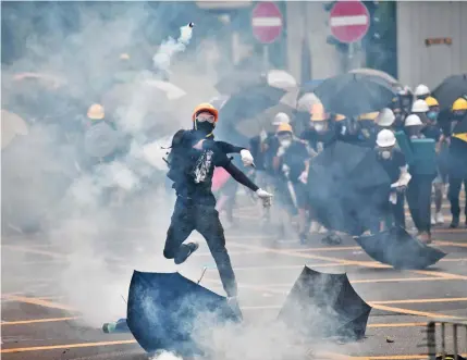  ?? Photo: AFP ?? A protEstEr tHrows A tEArGAs CAnIstEr BACk At PolICE.
