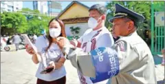  ?? HONG MENEA ?? A police officer with a NEC armband guides voters during the commune council elections in the capital’s Tuol Kork district in 2022.