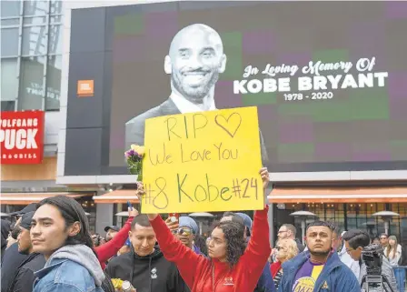  ?? PHILIP CHEUNG/THE NEW YORK TIMES ?? Mourners gather Sunday for Kobe Bryant, the retired Lakers star, outside of the Staples Center in Los Angeles. Bryant, 41, and his daughter Gianna, 13, died in a helicopter crash in Calabasas, California, on Sunday, along with seven others.