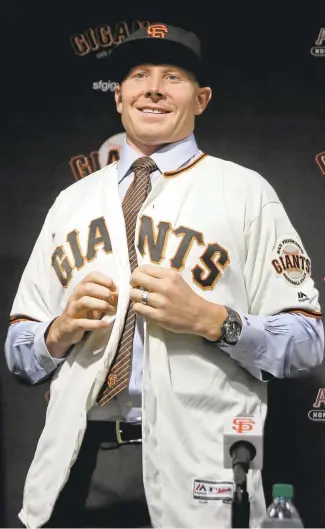  ?? ERIC RISBERG/ASSOCIATED PRESS ?? New Giants closer Mark Melancon buttons his jersey during a news conference Friday in San Francisco.
