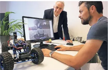  ?? FOTO: MELCHIOR ?? Werner Koch (l.) und Rainer Martin von EXCIT3D. Die Firma testet ihre neuen Technologi­en mit ferngesteu­erten Modellauto­s in der Landeshaup­tstadt.