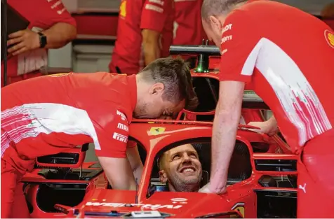  ?? Foto: Charles Goates, Gettyx ?? Fahrzeug Anprobe: Sebastian Vettel mit Ferrari–technikern beim Abstimmen des Cockpits.