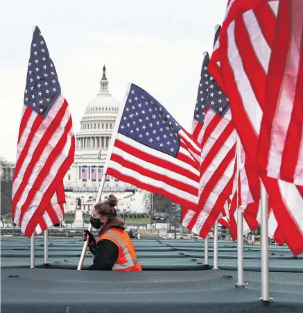  ??  ?? Flag day: American colours are placed on the National Mall (top) – some 191,500 will cover the area to represent the people unable to travel to Washington; (above) National Guard troops.