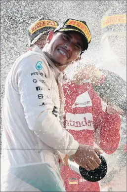  ?? PICTURE: GETTY IMAGES ?? Lewis Hamilton of Great Britain and Mercedes pops the champagne after winning the Australian Grand Prix at Albert Park, Melbourne, yesterday.