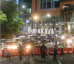  ?? ALFIAN RIZAL/JAWA POS ?? HARUS PUTAR BALIK: Petugas menutup jalan masuk ke Surabaya di sekitar bundaran Waru. Langkah itu dilakukan untuk mengurangi mobilitas warga luar kota yang akan merayakan pergantian tahun.