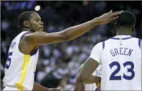  ?? TONY AVELAR — THE ASSOCIATED PRESS ?? Golden State Warriors forward Kevin Durant (35) taps forward Draymond Green (23) on the head after scoring against the Cleveland Cavaliers during the second half of an NBA basketball game in Oakland Monday. The Warriors won 99-92.