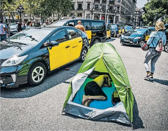  ?? LLIBERT TEIXIDÓ ?? La vía pública, ocupada.Untaxista durmiendo en una tienda de campaña ayer por la mañana tras pasar la noche en la calle