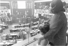  ?? BOBBY CALVAN/AP ?? Meralyn Kirkland holds her granddaugh­ter Kaia Rolle as legislator­s work on the House floor Wednesday. Florida lawmakers had a chance to stop police from arresting small children like Rolle except in rare circumstan­ces. They settled for far less.