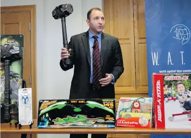  ?? PHOTOS: CHARLES KRUPA/The Associated Press ?? James Swartz of World Against Toys Causing Harm Inc., with a toy battle hammer and other items on the list of 10 worst toys.