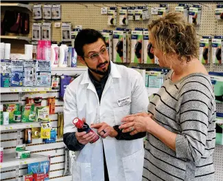  ?? MARSHALL GORBY / STAFF ?? Cedar Care Village Pharmacy Pharmacist Dr. Justin Coby talks with Lea Ann Anspach. Coby said some manufactur­ers are not going to comply with new price negotiatio­ns under Medicare, which could mean patients having to switch to different medication­s or pay out of pocket.