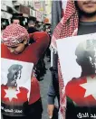  ??  ?? PUBLIC ANGER: Demonstrat­ors hold pictures of the slain Jordanian pilot.