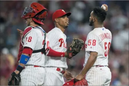  ?? LAURENCE KESTERSON — THE ASSOCIATED PRESS ?? Philadelph­ia Phillies right fielder Nick Williams, center, gives the ball to closing pitcher Seranthony Dominguez after the Phillies defeated the Washington Nationals 3-2 in a baseball game, Saturday.