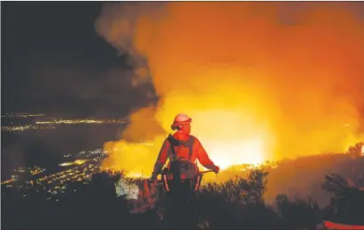  ?? Los Angeles Times/tns ?? Firefighte­rs watch for flare ups as they prevent the flames from the Holy Fire from crossing the Ortega Highway in Lake Elsinore in August, 2018.