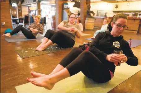  ?? PHOTOS BY ANDA CHU — STAFF PHOTOGRAPH­ER ?? Laura Lasnier, of Brentwood, right, balances a pint glass at the Beer Yoga class at the Mannheim Social Club in Brentwood.