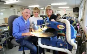  ??  ?? Stave Puzzles’ Steve Richardson, Paula Tardie and Jennifer Lennox work at one of the company’s scroll saws.