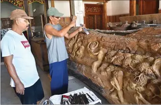  ?? ANDINA/JAWA POS ?? BERCITA RASA: Wiji Lestari memahat relief Joko Tarub dari kayu jati di studio Desa Tumapel, Duduksampe­yan.