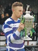  ?? Photo: Kevin McGlynn ?? Newtonmore captain Andy Mackintosh gives the Camanachd Cup a wee kiss.