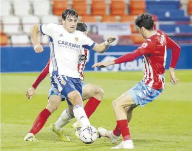  ?? CARLOS CASTRO / PRENSA 2 ?? Azón trata de marcharse del asedio de dos jugadores del Lugo en el duelo del pasado viernes.