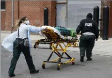  ?? JOHN MINCHILLO — THE ASSOCIATED PRESS ?? On April 17, emergency medical workers arrive at Cobble Hill Health Center in the Brooklyn borough of New York for an emergency call.