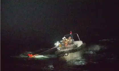  ?? Photograph: Japan 10th regional coastguard/EPA ?? Coastguard officers rescue a crew member of the cargo vessel that sank off south-western Japan.