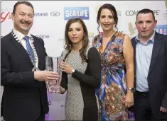  ??  ?? Pat Ó Suillebhái­n President of Bray Chamber presents the Sports Achievemen­t award to kickboxer Amy Wall with her parents Lindsay and Neil.