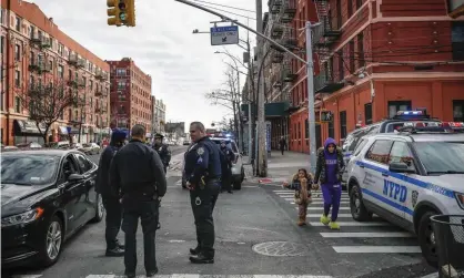  ??  ?? Police officers stand on the corner of 163rd and Fox Street at the scene of a police-involved shooting in the Bronx, New York, on 9 February. Photograph: John Minchillo/AP