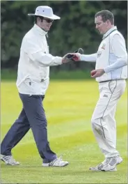  ?? FM2612664 ?? SAFE KEEPING: Ashford Town’s Peter Shields hands the umpire his cap before starting a new over