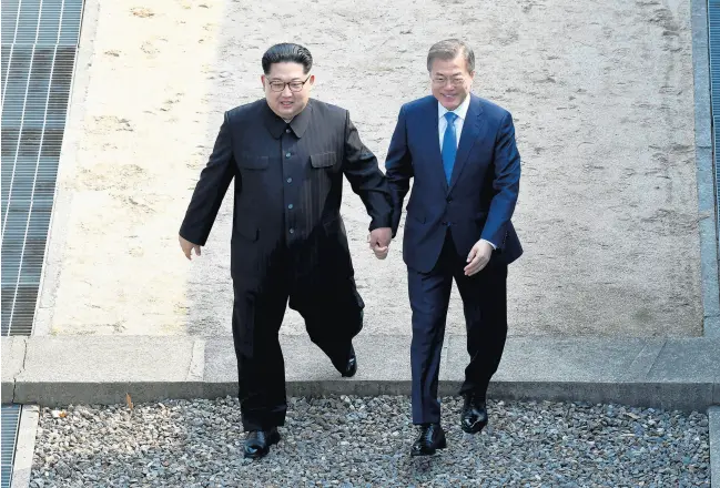  ?? AP ?? North Korean leader Kim Jong Un, left, and South Korean President Moon Jae-in cross the military demarcatio­n line at the border village of Panmunjom in the Demilitari­zed Zone on April 27, 2018. Moon has worked behind the scenes to try to improve long-hostile relations with North Korea and assert effective leadership more widely in Asia.