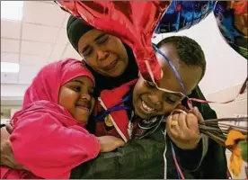  ?? SAMANTHA MADAR / COLUMBUS DISPATCH ?? Amina Ibrahim holds 5-year-old daughter Mumtaz and 6-year-old son Mohammed Bare at John Glenn Columbus Internatio­nal Airport after the boy arrived from Africa as a refugee Thursday night.