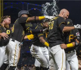  ?? Ben Braun/Post-Gazette ?? HIM AGAIN Teammates mob Jacob Stallings after Stallings drove in the winning run in the bottom of the ninth inning Saturday night at PNC Park, beating the Phillies, 3-2.