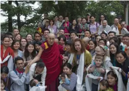  ?? — AP ?? Tibetan spiritual leader the Dalai Lama, in red robes, poses for a group photo with devotees at the Tsuglakhan­g temple in Dharmsala, India, on Monday. The Tibetan leader spoke to a group of Indian and foreign tourists on secular ethics and the...