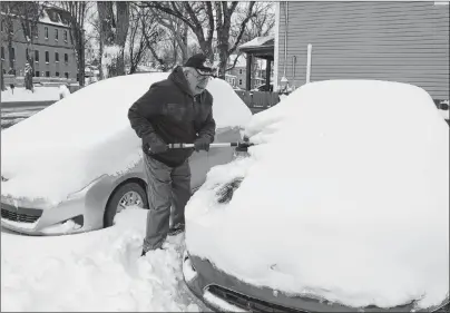  ?? KEIGAN MACLEOD/SPECIAL TO THE POST ?? Norman MacLean helped his neighbours by clearing snow off their cars in Sydney on Monday morning.