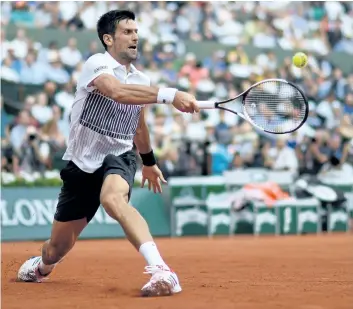  ?? CHRISTOPHE SIMON/AFP/GETTY IMAGES ?? World No. 2 Novak Djokovic returns the ball to 41st-ranked Diego Schwartzma­n during their match Friday at the French Open in Paris.