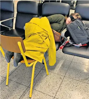  ?? ?? A Gatwick customer sleeps in the South Terminal amid flight delays and cancellati­ons