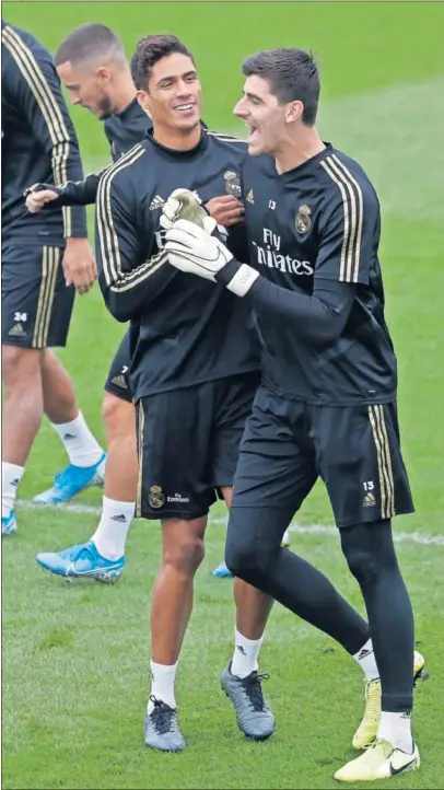  ??  ?? Courtois bromea con Varane en la sesión preparator­ia de ayer en Valdebebas.