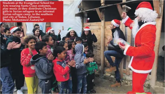  ??  ?? Students at the Evangelica­l School for Arts wearing Santa Claus costumes, play music as they distribute Christmas gifts to Syrian refugees in an informal Syrian refugee camp, in the southern port city of Sidon, Lebanon. Photo: Mohammed Zaatari/AP