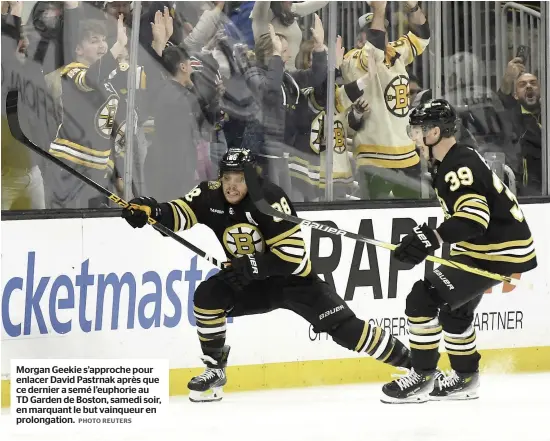  ?? PHOTO REUTERS ?? Morgan Geekie s’approche pour enlacer David Pastrnak après que ce dernier a semé l’euphorie au TD Garden de Boston, samedi soir, en marquant le but vainqueur en prolongati­on.