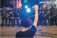  ?? MICHAEL CLEVENGER COURIER JOURNAL VIA THE ASSOCIATED PRESS ?? Police hold off protesters for Breonna Taylor early Friday in Louisville, Ky. Taylor, a Black woman, was fatally shot by police in her home in March.