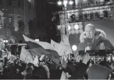  ?? Mladen Antonov, AFP/Getty Images ?? People listen to then-presidenti­al candidate, President Vladimir Putin during a rally and a concert celebratin­g the fourth anniversar­y of Russia’s annexation of Crimea at Manezhnaya Square in Moscow on March 18.